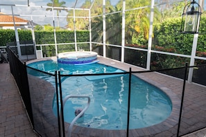 Tropical pool & spa retreat with safety fence—ideal for families & relaxing