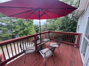 Top floor corner porch, lighted umbrella, bistro lights coming, dining outside!