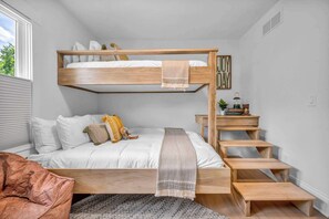 This room features a queen bed at the bottom and a twin lofted bed above, offering comfort and convenience for families or small groups seeking a restful stay.