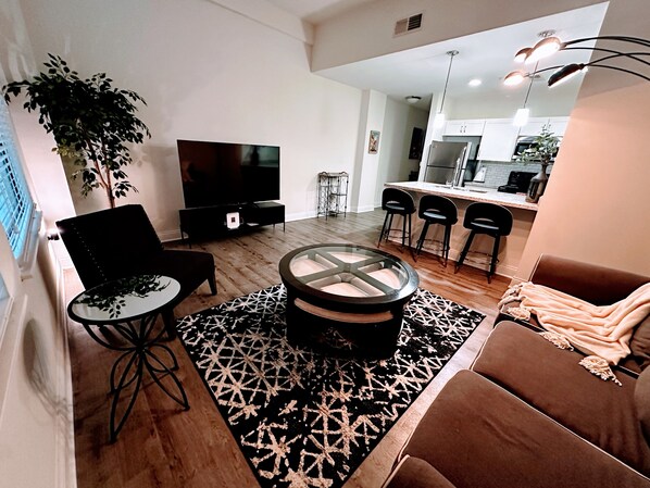 Living Room with 65" smart TV, large windows allow great natural light.