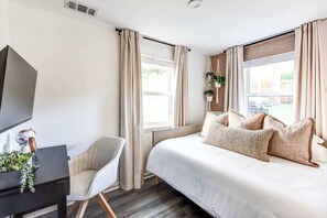 Relax in comfort: This bright bedroom features a plush white full size bed with premium 
memory foam mattress, smart TV, dedicated workspace, and large windows for plenty of 
natural light.