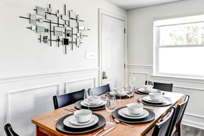 Gather around the spacious wooden dining table set for six. Enjoy meals in style with 
modern décor, comfortable seating, and plenty of natural light from the bright window.  