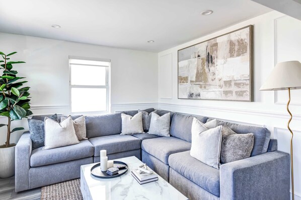 Settle into the spacious living room, complete with a cozy L-shaped sofa, stylish accents, and serene views—ideal for a peaceful break after your city adventures.