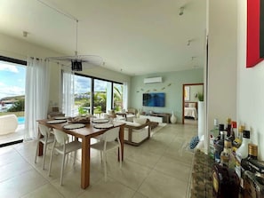 The villa features a stylish dining table for six, perfect for enjoying meals with family and friends. Its elegant design complements the open-concept living space, creating a welcoming and comfortable atmosphere for dining and entertaining.