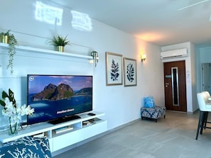 The living room is equipped with a large smart TV, offering a wide selection of streaming options for entertainment, so you can relax and enjoy your favorite shows and movies.