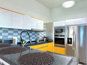 The modern kitchen is fully equipped with high-end appliances, sleek countertops, and stylish cabinetry, offering both functionality and design for preparing meals in comfort and style.