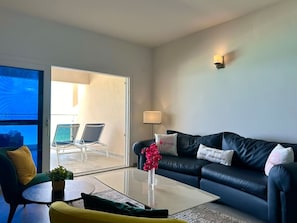 The living room is highlighted by a large picture window that frames stunning views of the ocean, filling the space with natural light and offering a seamless connection to the breathtaking surroundings.