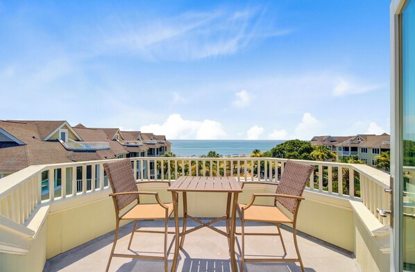 Sundrenched balcony with outdoor seating and stunning ocean views!