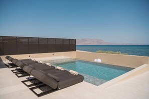 The pool area is equipped with 6 sun beds, 2 umbrellas, and a poolside shower.