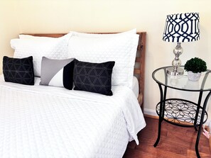 This second bedroom has a bright space and a queen bed, closet, and nightstand.