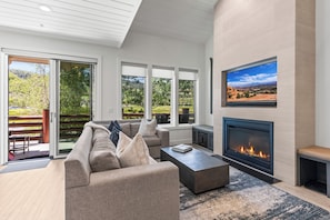 Chaparral 204's living room with gas fireplace, flat screen TV, and large windows with views of Deer Valley Resort..