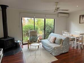 Living area with wood heater, ceiling fan and reverse cycle air conditioner