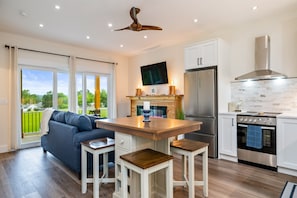 Warm wood tones, electric fireplace, and cozy seating set the tone for a relaxing getaway.