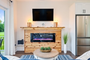 Lounge in comfort with a view! This open-concept living area leads out to a deck overlooking peaceful greenery.