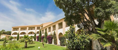 Mediterranean-style architecture nestled in lush Corsican gardens creates a relaxing, seaside ambiance.