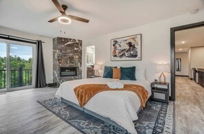 Spacious primary bedroom with king bed, fireplace, private balcony access, and en-suite bath—your personal retreat.