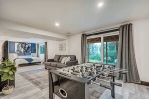 Enjoy friendly competition at the foosball table or kick back in the cozy sitting area, all while taking in serene woodland views. A private bedroom suite is just steps away for added comfort.