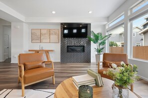 Bright living room with fireplace, stylish decor, ideal for work and relaxation.