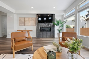 Bright living room with fireplace, stylish decor, ideal for work and relaxation.