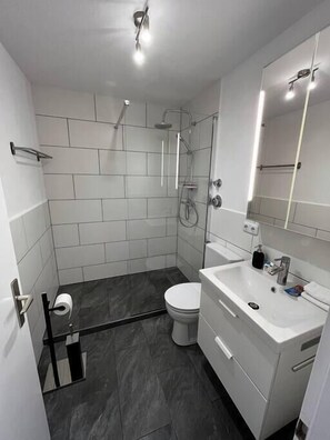 Modern bathroom with towels and hair dryer.