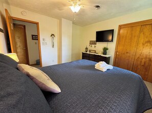 Second queen bedroom with smart TV, closet space, and luggage racks.