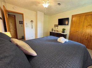 Second queen bedroom with smart TV, closet space, and luggage racks.