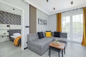 A stylish living room with a gray designer sofa, a wooden coffee table and decorative pillows combines modernity with homely warmth.