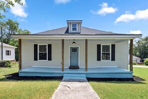 Welcome to our home, where a brightly colored porch and front door offer a cheerful first impression and set the tone for a warm, relaxing stay.