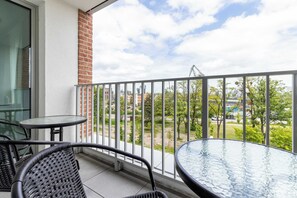 A balcony with a view of the green surroundings and comfortable outdoor furniture is a perfect place to relax.