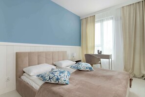 A cozy bedroom with a blue wall and a large bed offers a comfortable and peaceful rest.