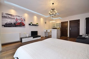 A bedroom area with a double bed and a TV opposite creates a space conducive to relaxation and rest.