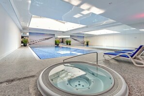 A luxurious spa area with a jacuzzi, ambient lighting, and relaxation loungers for ultimate comfort.