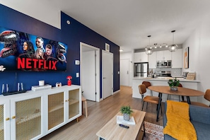 Colorful open-concept living area with Smart TV, dining nook, and modern kitchen