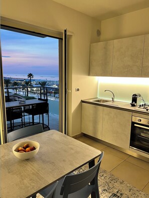 Kitchen and dining opening to the balcony with a sea view