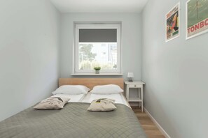 A bright bedroom with a comfortable bed and minimalist decor ensures restful sleep.