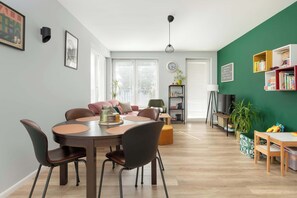 Large windows fill the living room with light, highlighting the elegance of the interior.