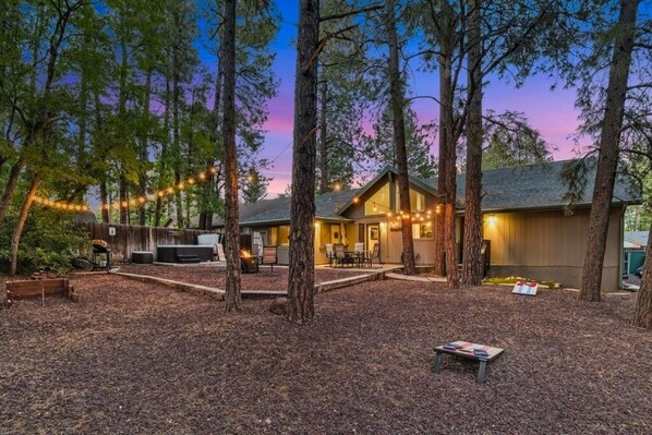The generous backyard is framed by towering pine trees and lush landscaping!
