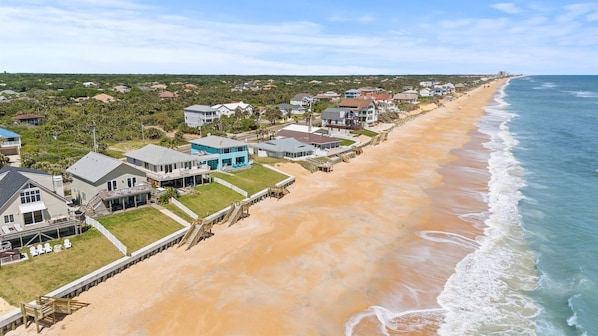 Miles of pristine coquina sand stretch endlessly as undulating waves crash rhythmically on your private beach paradise—where tranquil mornings and sunset strolls become treasured memories.