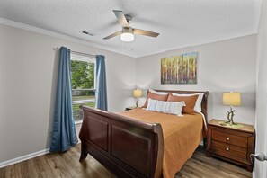 Cozy bedroom with queen bed and smart TV for relaxation and entertainment.