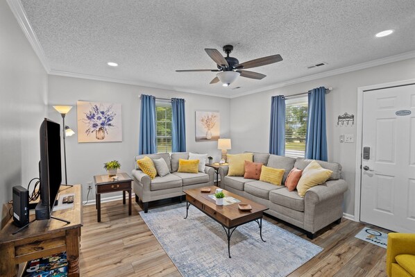 Cozy living room with 505" smart TV, fan & board games for fun.