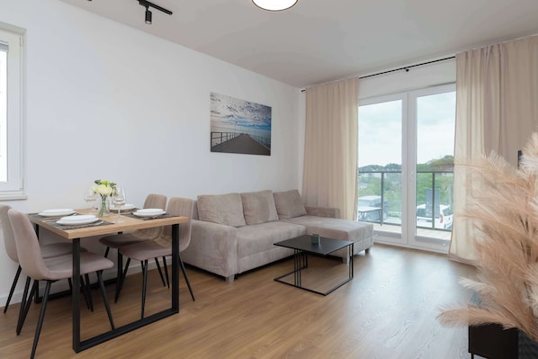 A spacious living room with a large balcony window provides perfect conditions for relaxing in natural light.