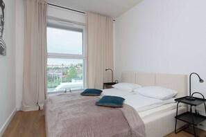 A bright bedroom with soft bedding and subtle decor ensures restful sleep and a cozy ambiance.