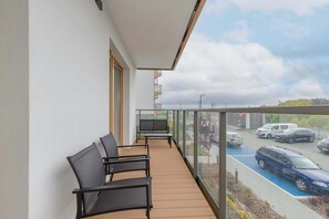 The balcony with comfortable chairs invites you to enjoy morning coffee overlooking the greenery.
