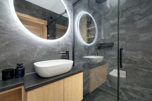 Bathroom with washing machine and towels.