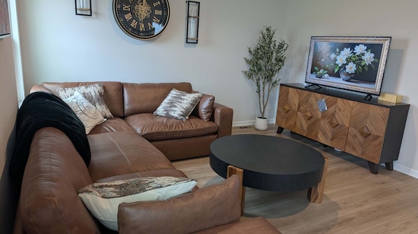 The living room features soft, inviting furnishings that make comfort a priority. It’s the ultimate space to relax, lounge, or catch up with loved ones.