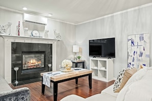 Living room with cozy sofa, fireplace, and smart TV for relaxing nights in.