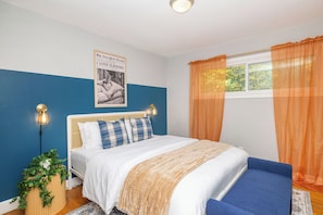 Bedroom with pastel coastal hues and queen bed