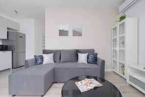 Another angle of the living room with a slightly different perspective, highlighting its open and airy design with white walls and neutral tones.