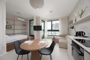 Studio with an elevated mattress, Smart TV and kitchenette with dining area.
