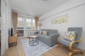 An open living area that combines a soft seating area, coffee table, and dining space in natural hues.